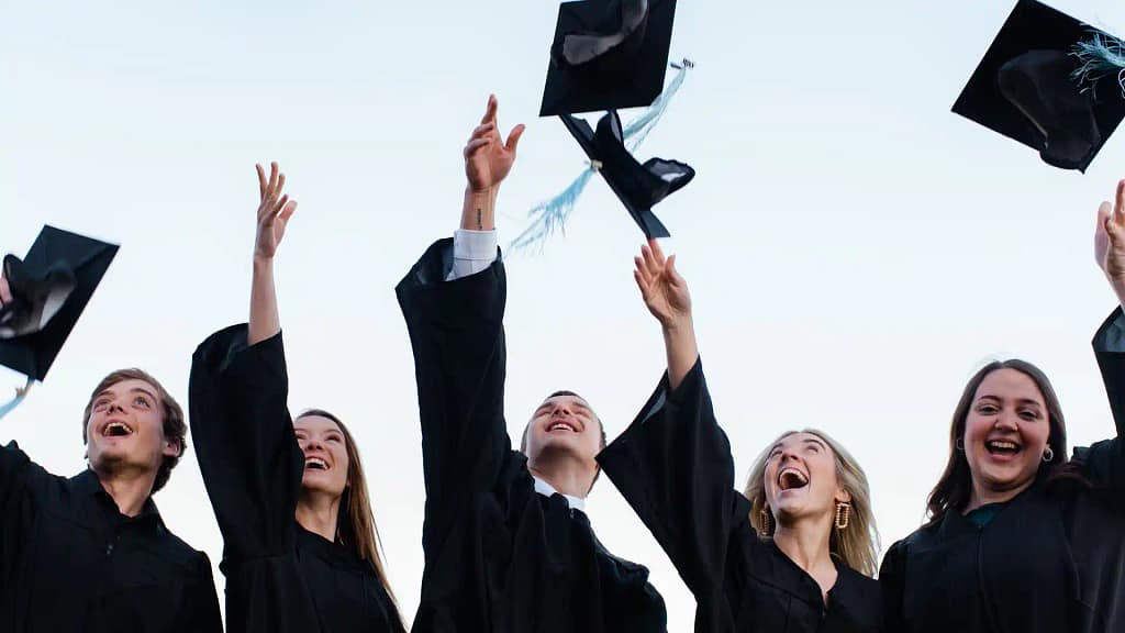 students throwing caps in the air