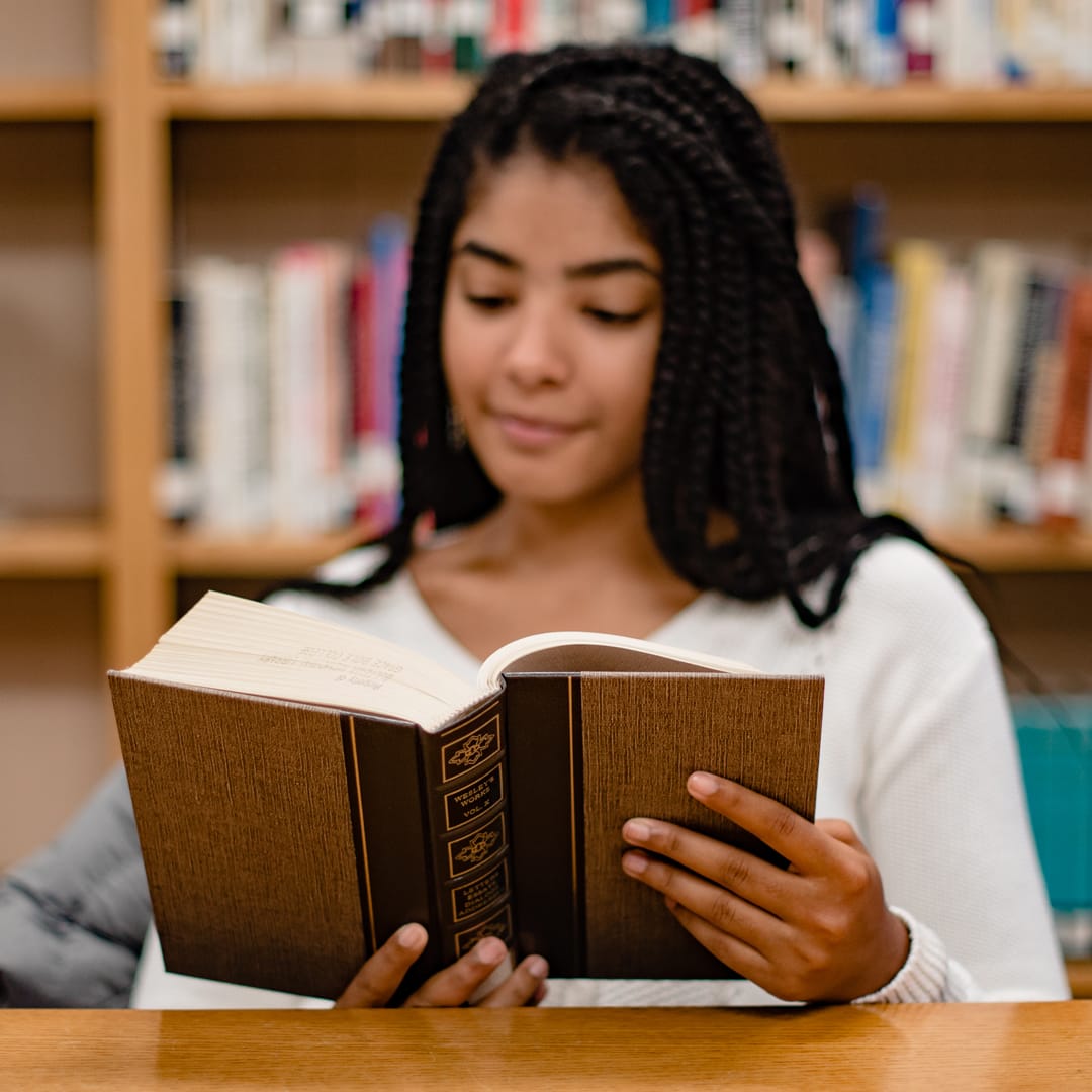 Grace student reading a book in the library