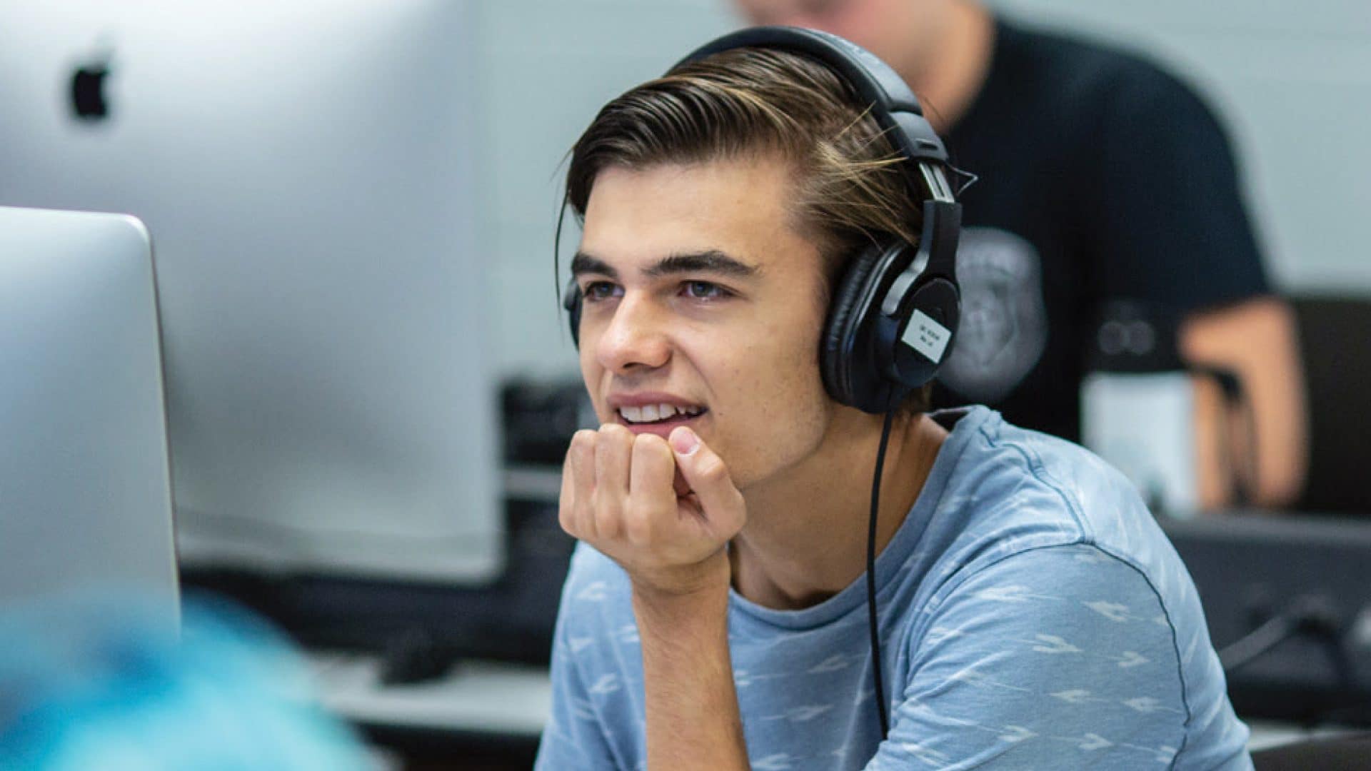 Journey-article-headers9 Two students talking to a professor in a classroom