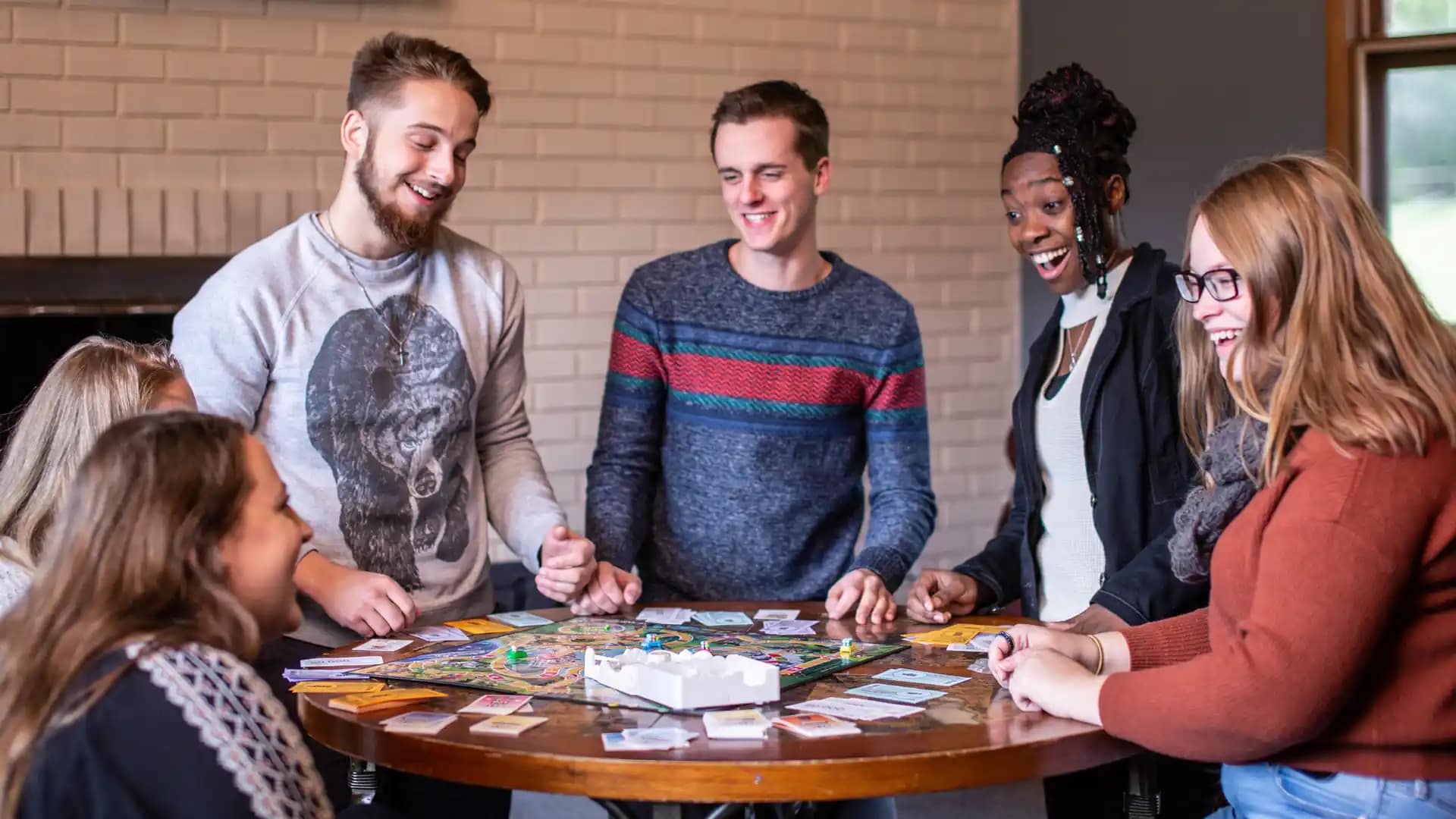 On-Campus-Students-Leadership-Opportunities A diverse group of On-Campus Grace Students around a table playing a board game.