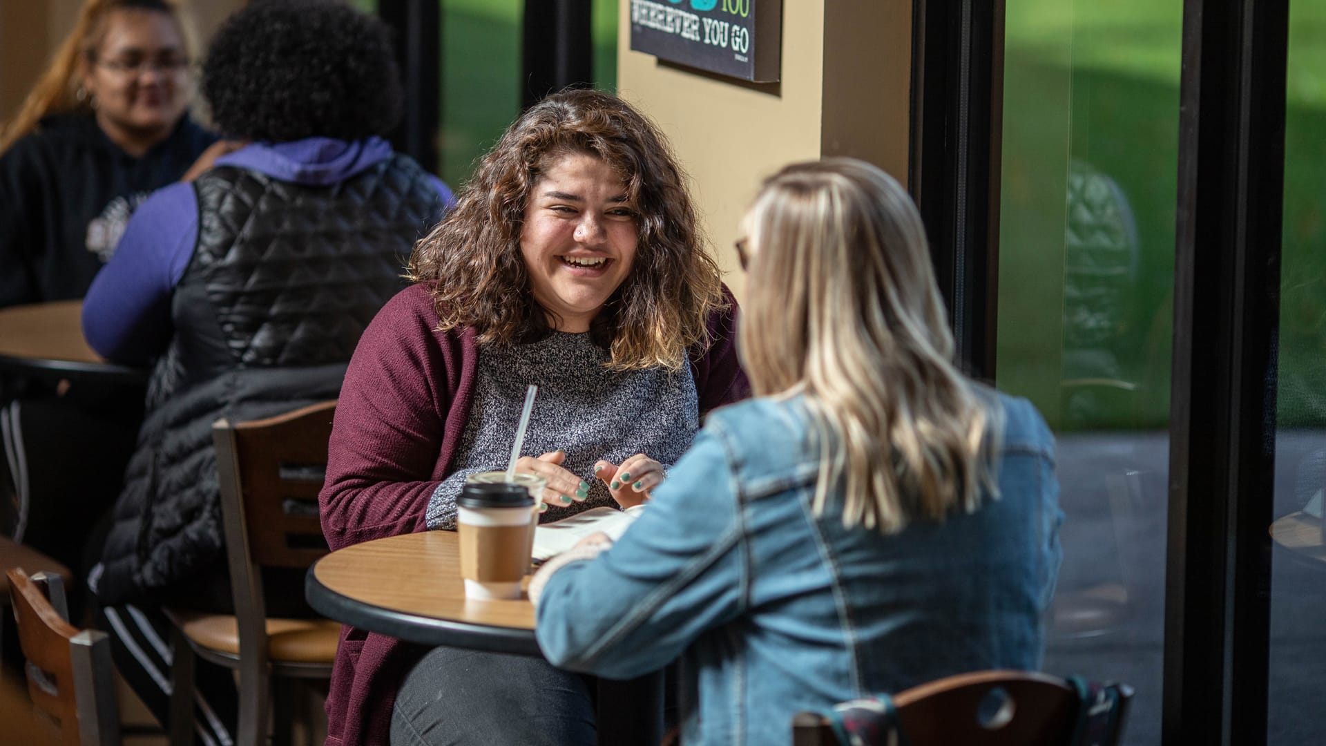 Student-Account-Payment Two female Grace students sitting at a table in the Student Commons.