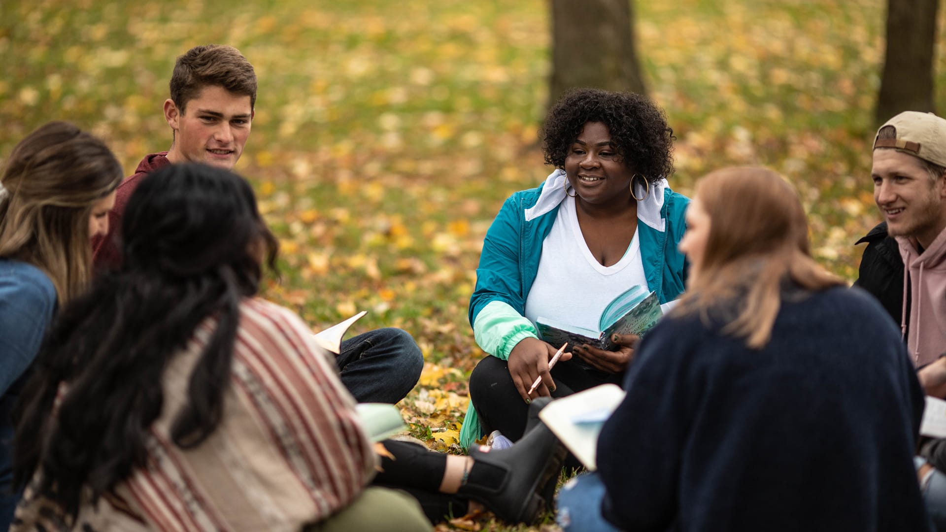 Student-Counseling A group of Grace Students sitting in a circle outside, doing a bible study.