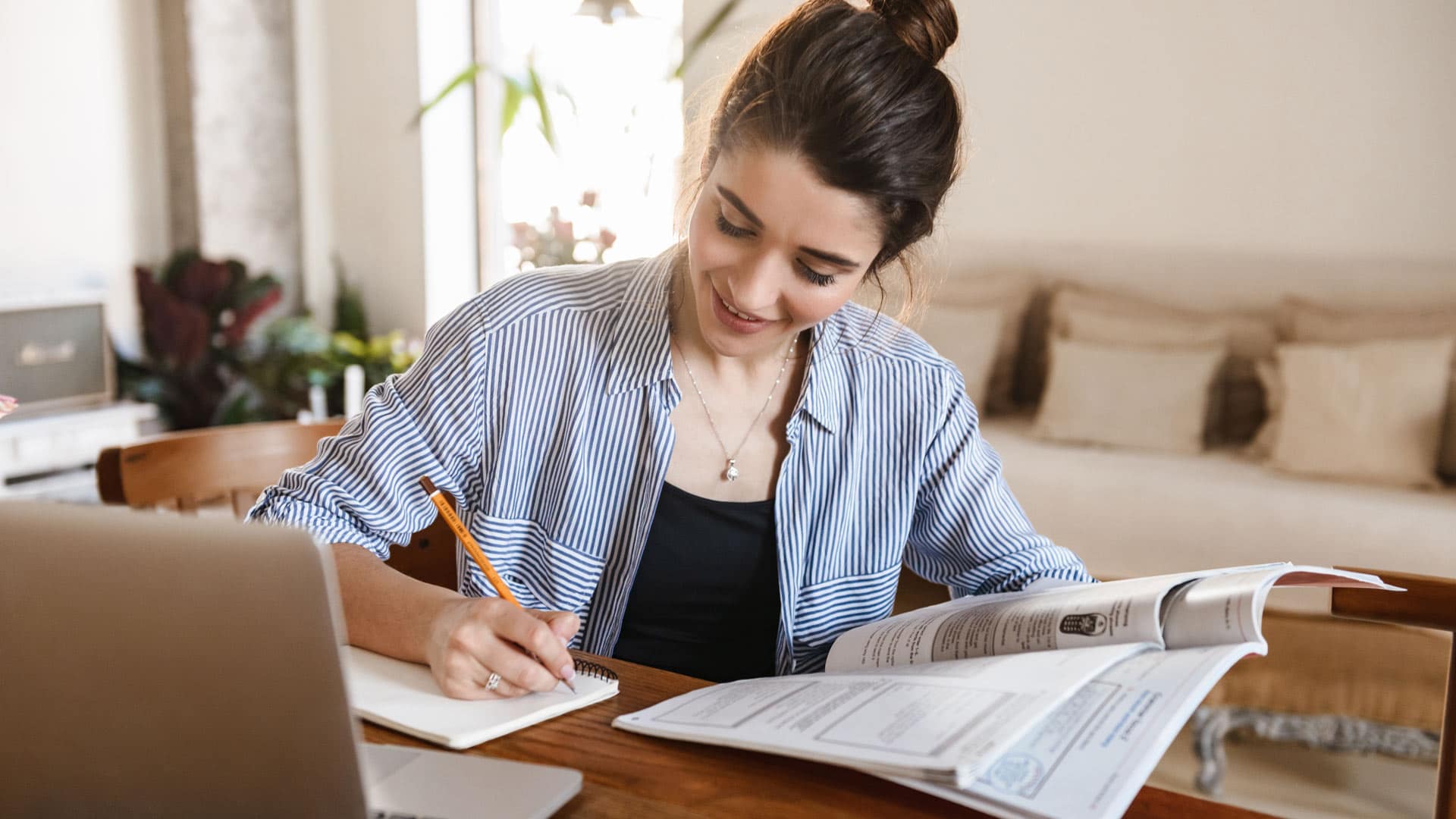 Free-Graduate-Course A Grace Online student studying in front of a laptop and books at home.