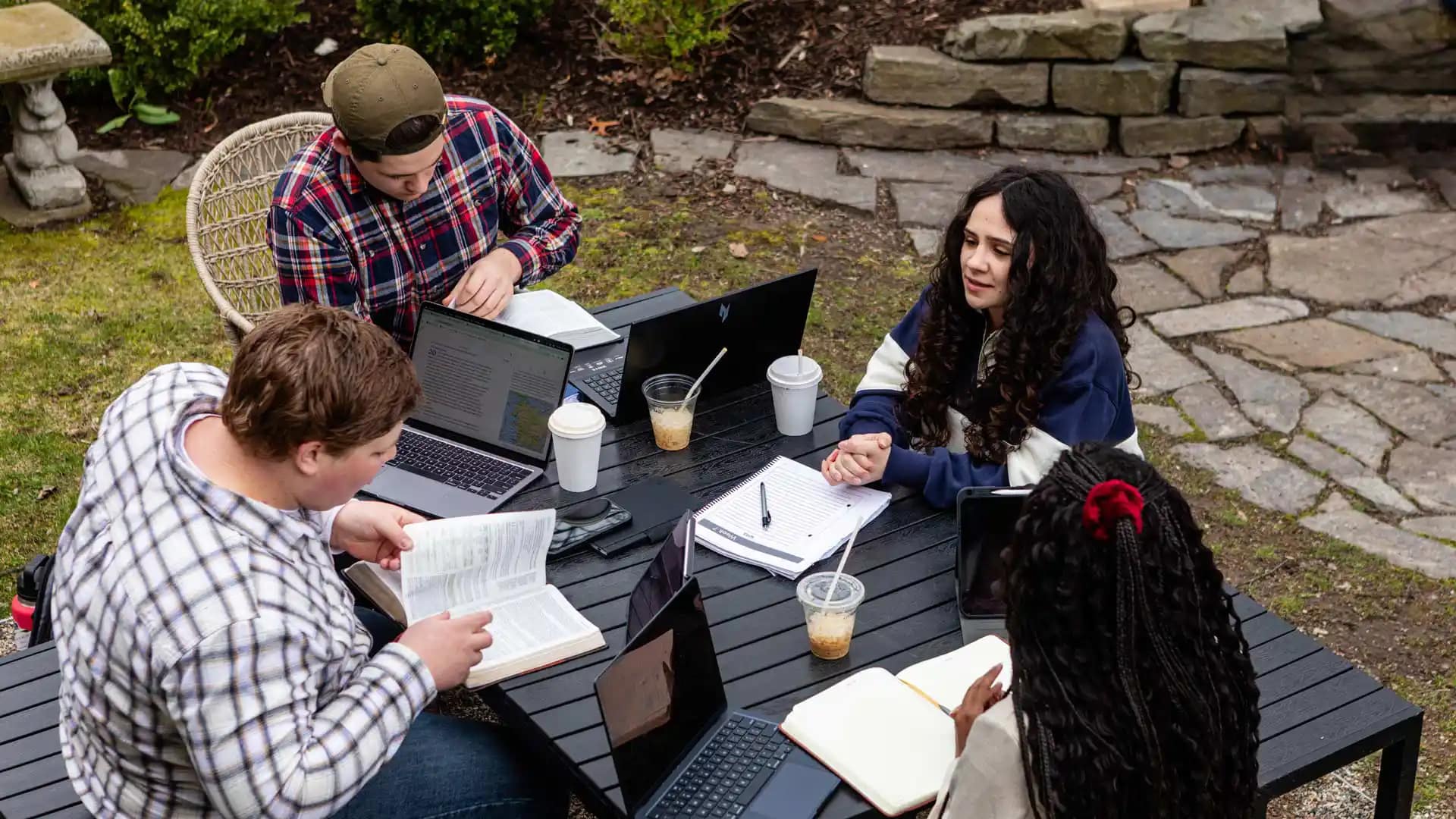 Grace-On-Campus-Students-3 A group of Grace students studying at a outdoor table.
