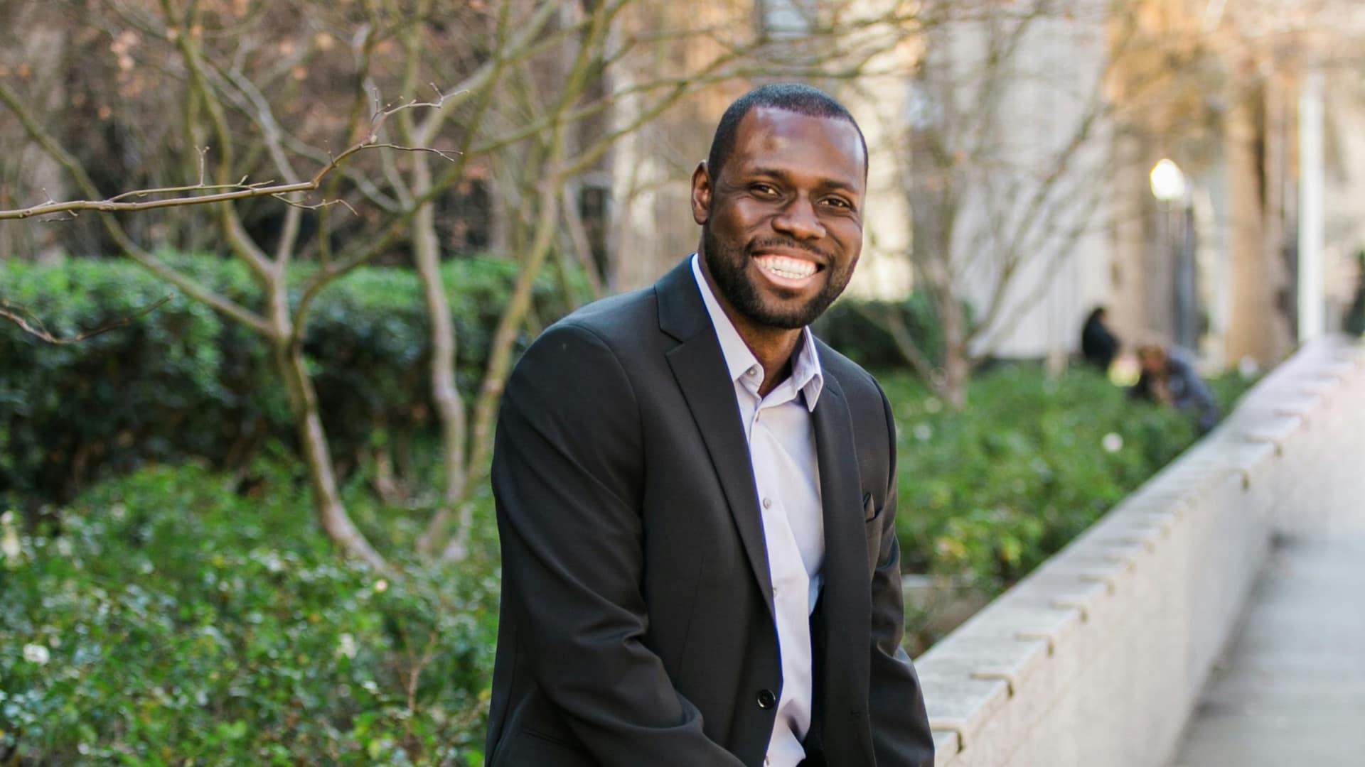 Open-Your-Options Grace student in a business suit, standing outside.