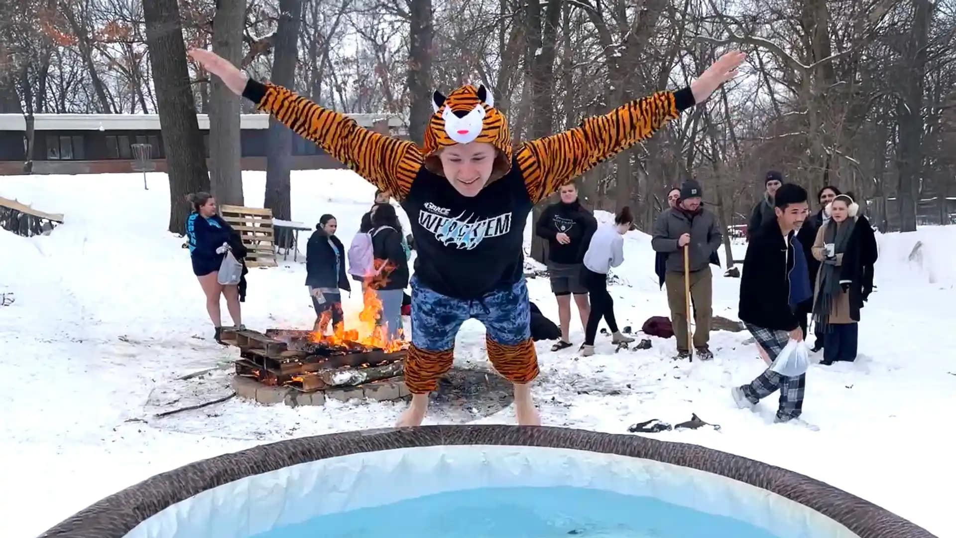 The-Big-Freeze A Grace student dressed up as a tiger, jumping into an ice bath outdoors for The Big Freeze event, fundraising for scholarships.