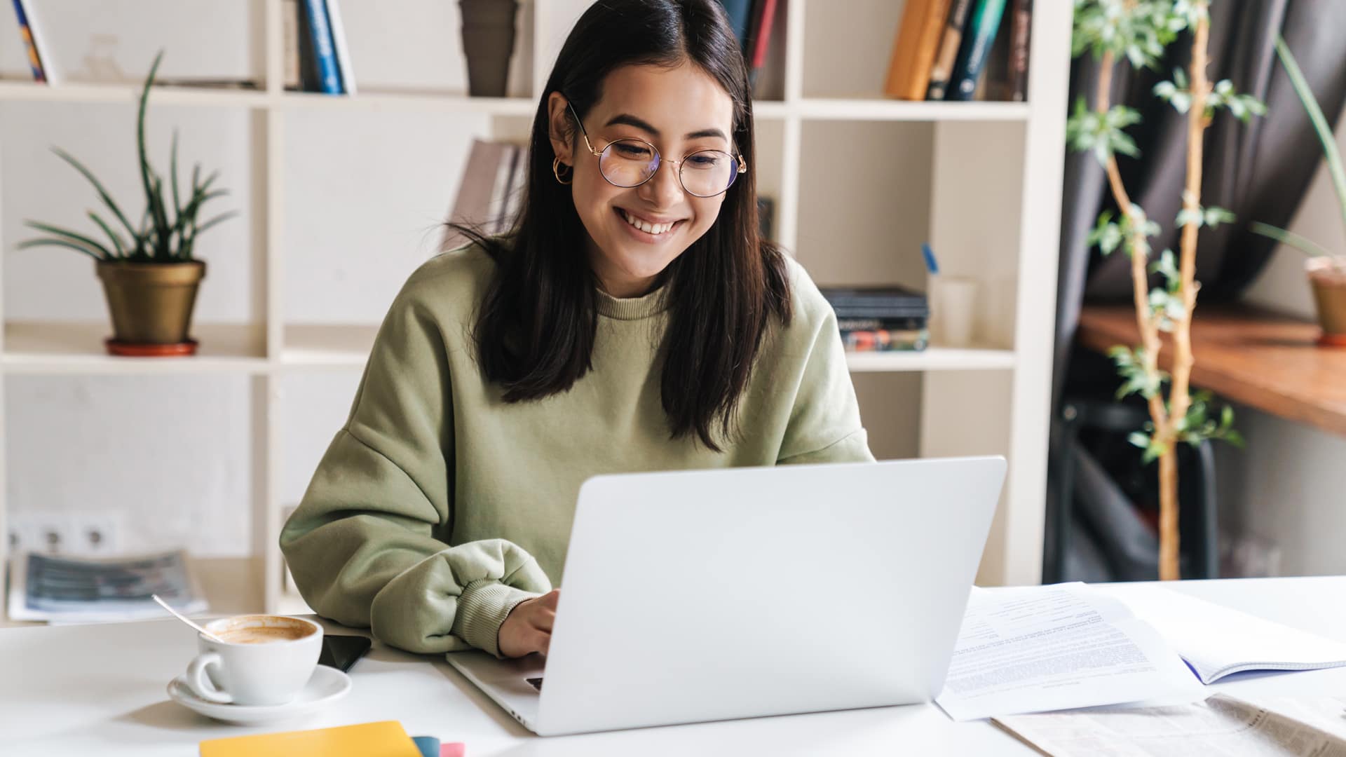 A happy Grace Online student working on a laptop