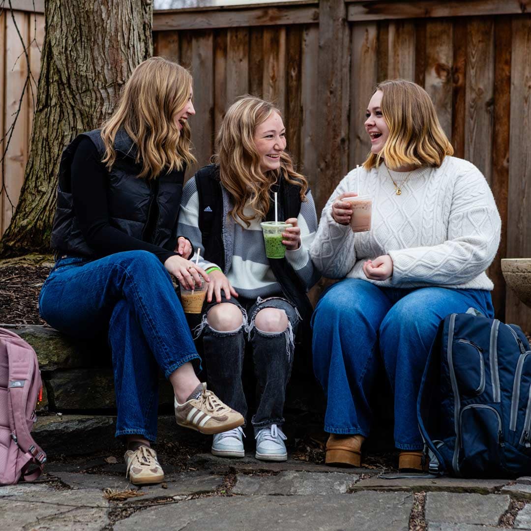Grace-On-Campus-Students-6 Happy Grace students sitting in a group outside